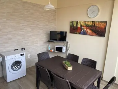 a dining room with a table and a washing machine at Casa Narciso - Mondello in Mondello