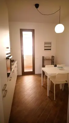 a kitchen with a table and a white table and a door at Loft 407 in Cinisi