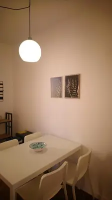 a dining room table with white chairs and a light fixture at Loft 407 in Cinisi