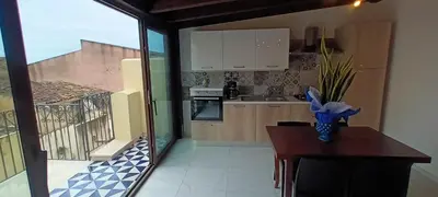 a kitchen with a table and a view of a balcony at Palazzo DS in Castellammare del Golfo