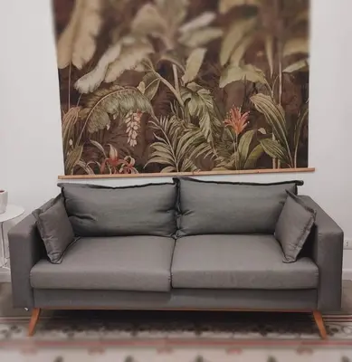 a couch in a living room with a painting on the wall at Piazza Vittoria Apartment in Carini