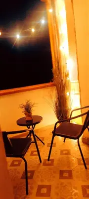 two chairs and a table on a balcony at night at Piazza Vittoria Apartment in Carini