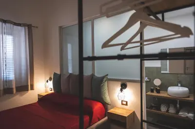 a bedroom with a red bed and a mirror at ZA HOUSE in Palermo