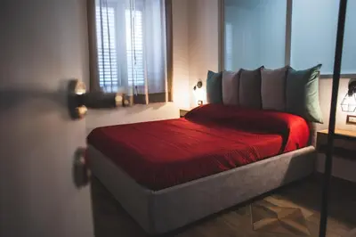 a bedroom with a red bed with a window at ZA HOUSE in Palermo