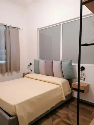 a bedroom with a bed and a large window at ZA HOUSE in Palermo