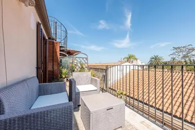 a balcony with wicker chairs and a table at Schiavuzzo Apartment with Terrace by Wonderful Italy in Palermo