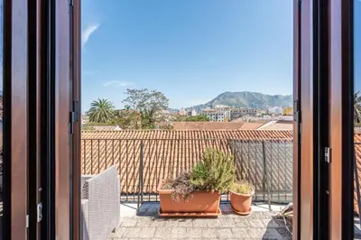 a balcony with potted plants and a view of a city at Schiavuzzo Apartment with Terrace by Wonderful Italy in Palermo