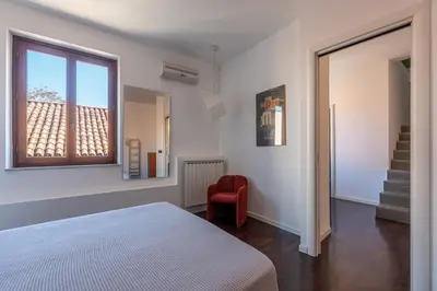 a bedroom with a bed and a window and a chair at Schiavuzzo Apartment with Terrace by Wonderful Italy in Palermo