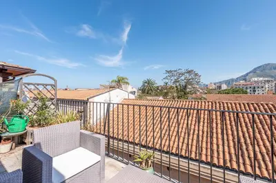 a balcony with a white chair and a roof at Schiavuzzo Apartment with Terrace by Wonderful Italy in Palermo