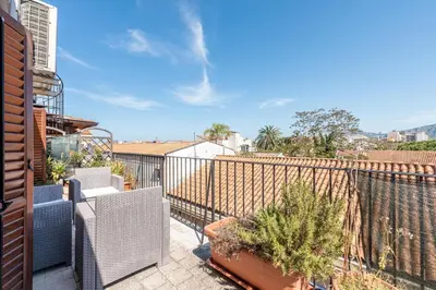 a balcony with chairs and plants on a fence at Schiavuzzo Apartment with Terrace by Wonderful Italy in Palermo