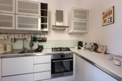 a kitchen with white cabinets and a sink and a stove at SHANTI HOLIDAY HOUSE in Palermo