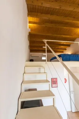 a staircase in a room with white walls and wooden ceilings at SHANTI HOLIDAY HOUSE in Palermo