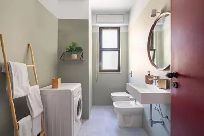 a bathroom with a sink and a washing machine at Aurum by DomuSicily in Mondello