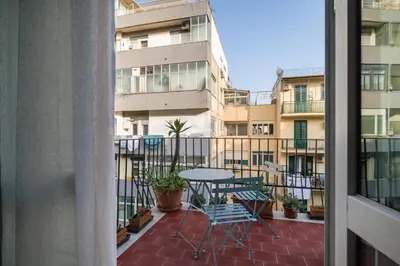 a patio with a table and chairs on a balcony at Giusà by DomuSicily in Palermo