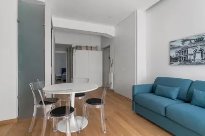 a living room with a blue couch and a table and chairs at Giusà by DomuSicily in Palermo