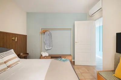 a bedroom with a white bed and a white door at Sole di Giada by DomuSicily in Mondello