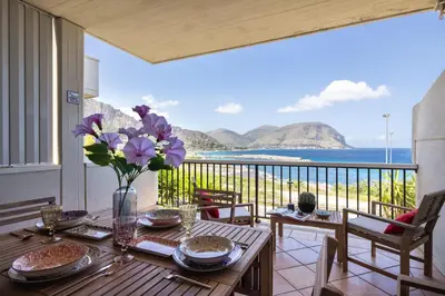 a dining table with a view of the ocean at Sole di Giada by DomuSicily in Mondello