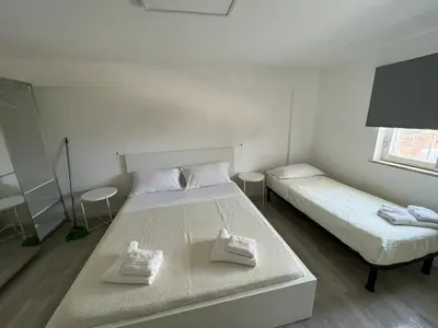 a bedroom with two beds and two chairs in it at Porta Addaura in Palermo
