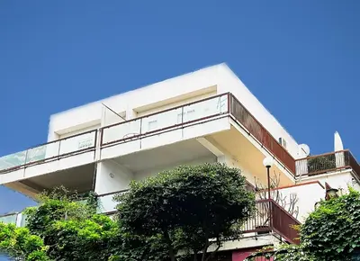 a white building with a balcony and trees at Porta Addaura in Palermo
