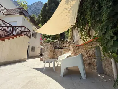 a patio with a table and chairs and an umbrella at Porta Addaura in Palermo