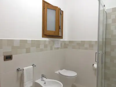 a bathroom with a toilet and a sink and a mirror at La Capinera Holidays in Santa Flavia