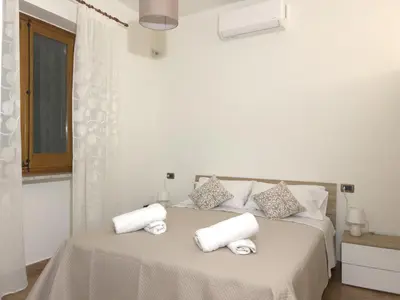 a white bedroom with a bed with towels on it at La Capinera Holidays in Santa Flavia