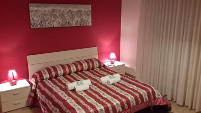 a red bedroom with a bed with two night stands at Case Saniela in Terrasini
