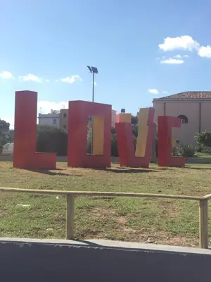 a large sign for the word love in a field at Case Saniela in Terrasini
