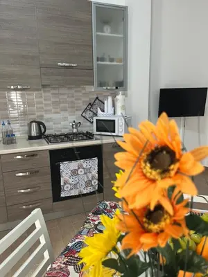 a kitchen with a table with a vase of sunflowers at Casa Corbezzolo in Balestrate