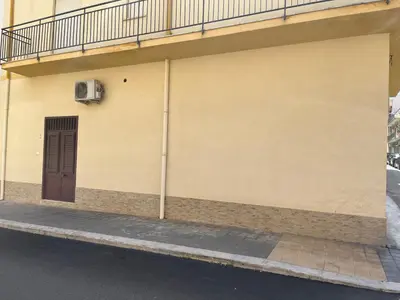 a building with a brown door and a balcony at Casa Corbezzolo in Balestrate