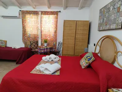a room with a red bed with towels on it at B&B Sikelia in Terrasini