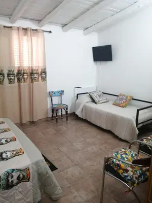 a room with two beds and a flat screen tv at B&B Sikelia in Terrasini