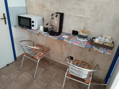 a kitchen with a counter with two chairs and a microwave at B&B Sikelia in Terrasini