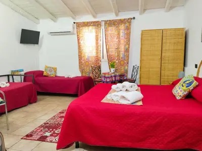 a room with two beds with red sheets at B&B Sikelia in Terrasini