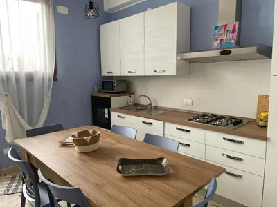 a kitchen with a wooden table and white cabinets at Dai Maestri Rubino in Vita