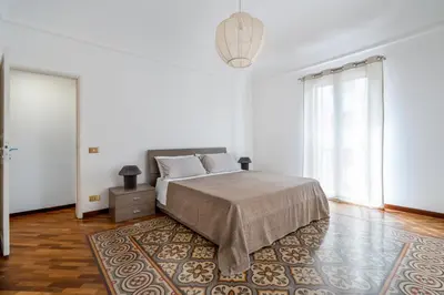 a white bedroom with a bed and a rug at Casa Bentivegna in Palermo