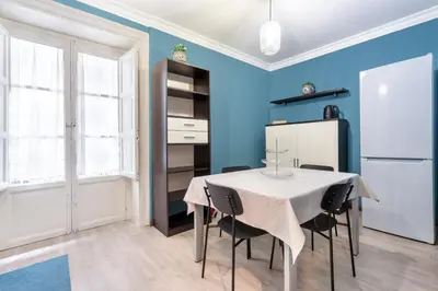 a kitchen with a table and chairs and a refrigerator at Casa Bentivegna in Palermo