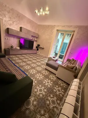 a living room with a couch and a tv at Elisir house in Palermo