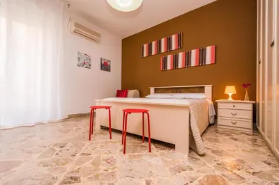 a bedroom with a bed and two red stools at Il Muretto in Lascari