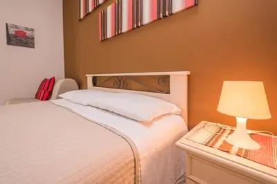 a bedroom with a bed and a table with a lamp at Il Muretto in Lascari