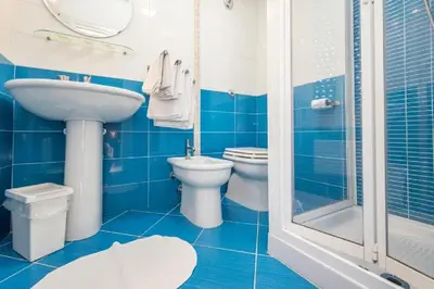 a blue bathroom with a sink and a toilet and a shower at Il Muretto in Lascari