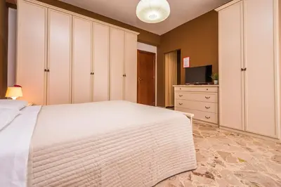 a bedroom with a large white bed and a dresser at Il Muretto in Lascari