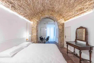a bedroom with a bed and a table with a mirror at Calderai 82 suites 1 e 2 in Palermo
