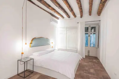 a white bedroom with a bed and a window at Calderai 82 suites 1 e 2 in Palermo