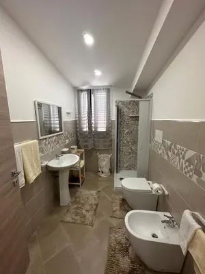 a bathroom with two sinks a toilet and a shower at Gravina in Trappeto