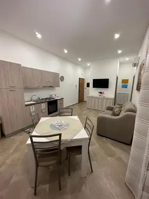 a kitchen and a living room with a table and chairs at Gravina in Trappeto