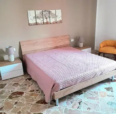 a bedroom with a bed with a pink comforter at little Italy in Castellammare del Golfo