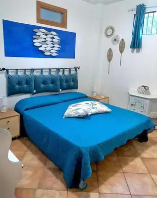a bedroom with a blue bed with a blue blanket at Casa Tequi a 200mt dal mare in Terrasini