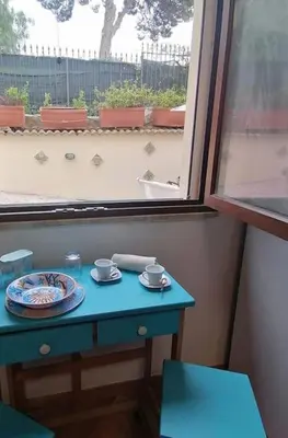 a blue table with a plate on it next to a window at Casa Tequi a 200mt dal mare in Terrasini
