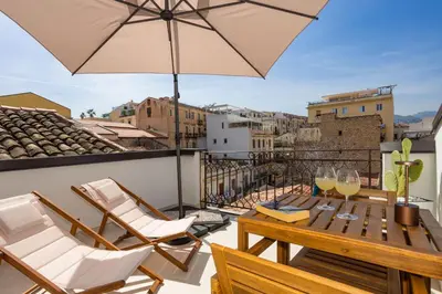 a balcony with a table and chairs and an umbrella at Le Terrazze dei Candelai 